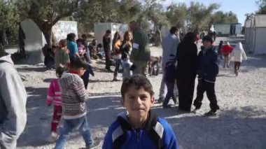 Lesvos, Yunanistan - 5 Kasım 2015: Kalabalık insan mülteci kampında. Çocuk göz kamera.