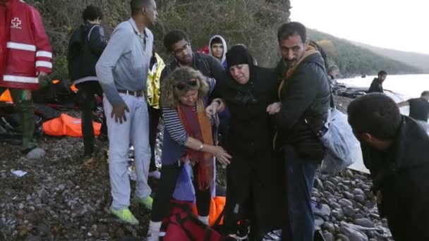 LESVOS, GRECIA - 5 NOV 2015: Voluntarios ayudan a las mujeres refugiadas a ir a la orilla . — Vídeos de Stock