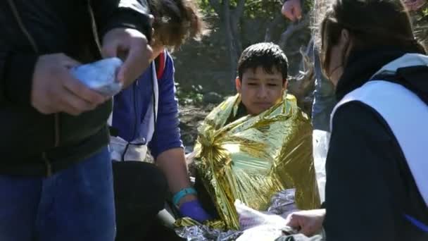 Lesvos, Yunanistan - 5 Kasım 2015: Dondurulmuş çocuk mülteci ısınma folyo. — Stok video