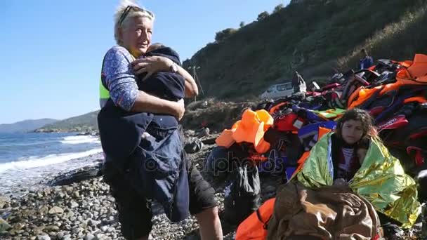 LESVOS, GRECIA - 5 NOV 2015: Voluntaria caliente por manta a un bebé refugiado . — Vídeos de Stock
