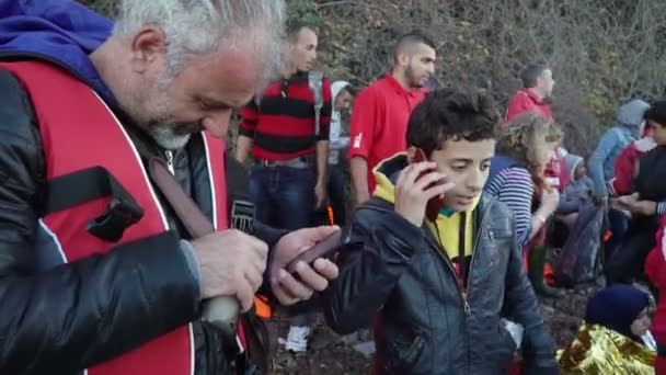 Lesvos, Grekland - 5 Nov 2015: En flykting pojke ringer för att säga att han simmade över havet. — Stockvideo