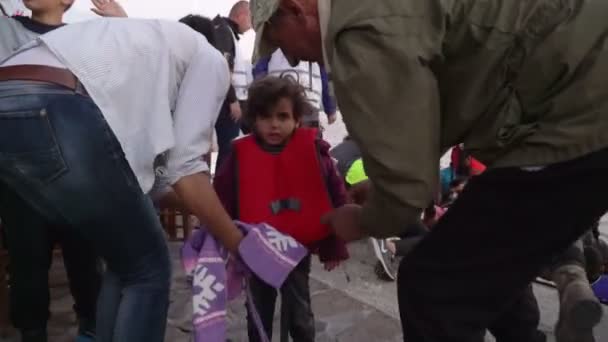 Лесбос, Греція - 5 листопада 2015: Біженців, які були врятовані в морі. Діти тягти човен спочатку. — стокове відео