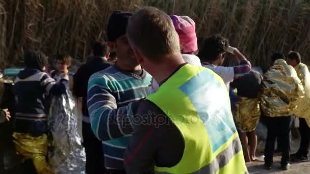LESVOS, GREECE - NOV 5, 2015: Volunteer passes the baby to his father. — Stock Video
