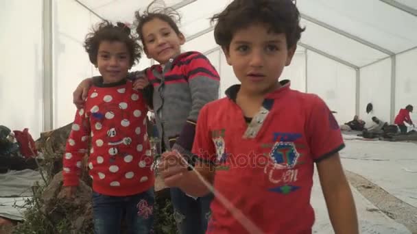 Лесбос, Греція - 5 листопада 2015: Біженців діти погляд на камеру в намет в таборі. — стокове відео