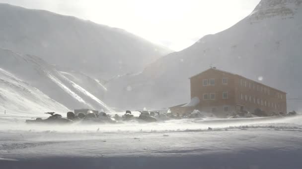 Longyearbyen, Svalbard. Het gebouw van hotel en sneeuwscooters die worden opgeveegd door de sterke wind. — Stockvideo