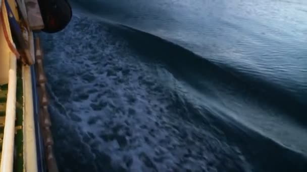 Vista nocturna de la costa con embarcación flotante. Olas . — Vídeo de stock