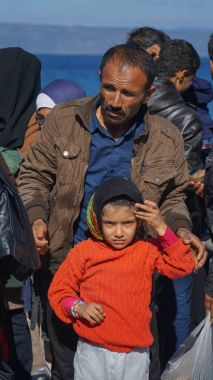 Lesvos, Yunanistan - 15 Kasım 2015: Mülteciler Yunan kıyısında. Baba ve kızı.