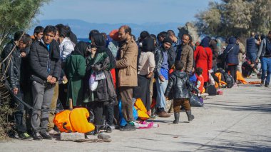 Lesvos, Yunanistan - 15 Kasım 2015: Mülteciler Yunan kıyısında. Otobüs beklerken.