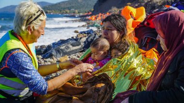 Lesvos, Yunanistan - 15 Kasım 2015: Volonteer ile yeni gelen tekne mülteciler.