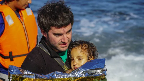 Lesbos, Grekland - 15 November 2015: Barn dras ur båten. — Stockfoto