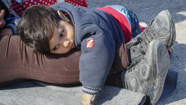 LESVOS, GRECIA - 15 NOVEMBRE 2015: Bambino stanco nel campo per rifugiati. Lesbo, Grecia . Immagine Stock