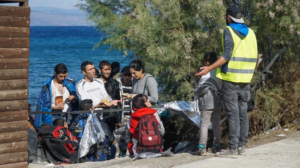 LESVOS, GRECIA - 15 NOVEMBRE 2015: Rifugiati sulla costa greca. Aspettando l'autobus . Immagini Stock Royalty Free