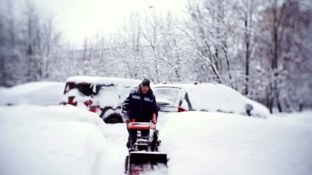 Le concierge dégage la piste avec un chasse-neige dans la cour d'un immeuble d'habitation . — Video