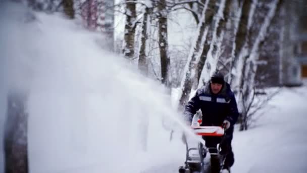 Уборщик очищает трассу снегоочистителем во дворе жилого дома . — стоковое видео