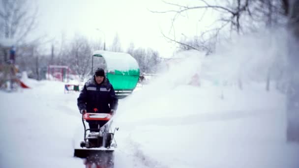 Talonmies raivaa radan lumiaura pihalla kerrostalon . — kuvapankkivideo