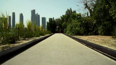 Komik küçük çocuk çalışır ve parkta trambolin yolda atlar. BAE, Sharjah, Al Noor Adası - Bahçe kelebek.