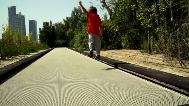 Ein Lustiger Kleiner Junge Rennt Und Springt Auf Der Trampolinbahn — Stockvideo