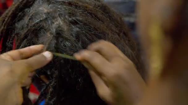 O processo de tecer dreadlocks em um salão indiano. — Vídeo de Stock