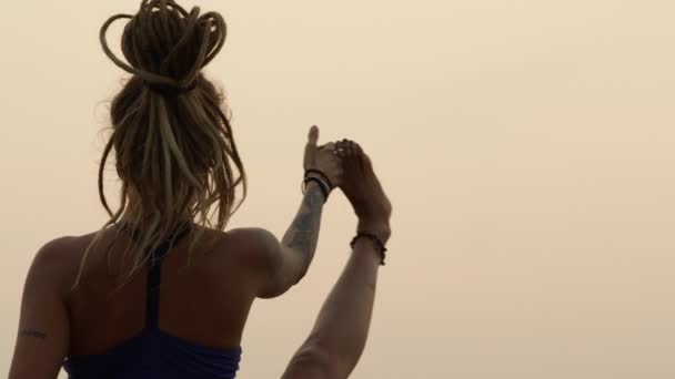 Арамбол, Гоа, Індія - 30 грудня 2019: Юна струнка дівчина в позі йоги на піщаному пляжі біля моря при заході сонця.. — стокове відео