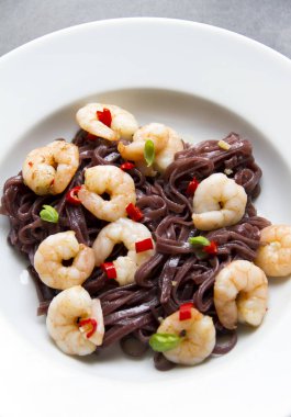 Karides, karides, beyaz masa, gri arka plan siyah pirinç noodle. 