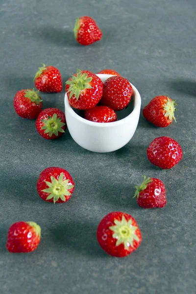 Çilek mavi ve beyaz tabak, gri arka plan.