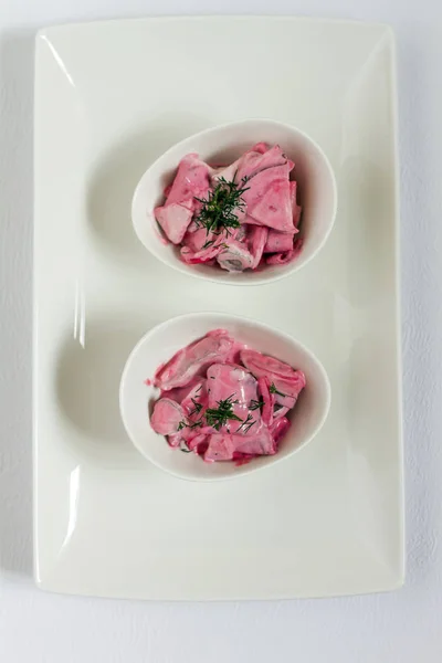 Ringa balığı salatası beetroots, elma ve soğan. Beyaz tabaklar, beyaz artalanları. İzole.