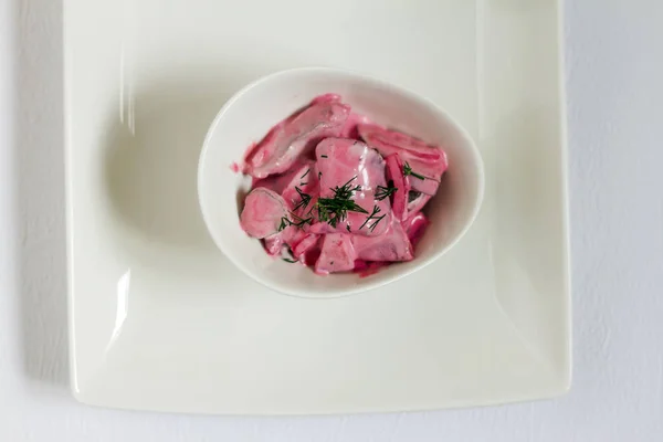 Ringa balığı salatası beetroots, elma ve soğan. Beyaz tabaklar, beyaz artalanları. İzole.
