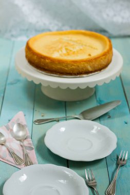 Kavrulmuş tereyağı ile peynirli kek. Mavi ahşap masa, beyaz tabaklar.