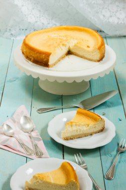 Kavrulmuş tereyağı ile peynirli kek. Mavi ahşap masa, beyaz tabaklar.