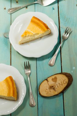 Kavrulmuş tereyağı ile peynirli kek. Mavi ahşap masa, beyaz tabaklar.