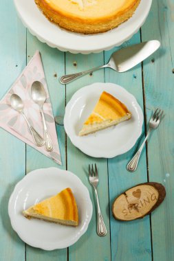 Kavrulmuş tereyağı ile peynirli kek. Mavi ahşap masa, beyaz tabaklar.