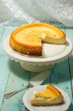 Kavrulmuş tereyağı ile peynirli kek. Mavi ahşap masa, beyaz tabaklar.