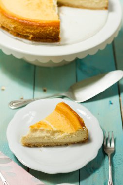 Kavrulmuş tereyağı ile peynirli kek. Mavi ahşap masa, beyaz tabaklar.