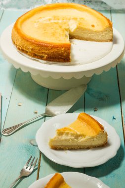 Kavrulmuş tereyağı ile peynirli kek. Mavi ahşap masa, beyaz tabaklar.