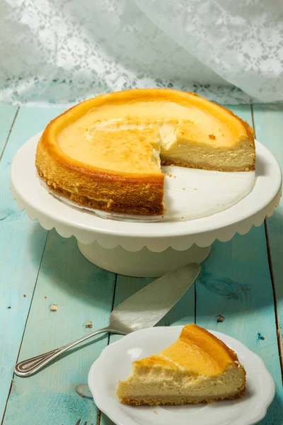 Kavrulmuş tereyağı ile peynirli kek. Mavi ahşap masa, beyaz tabaklar.