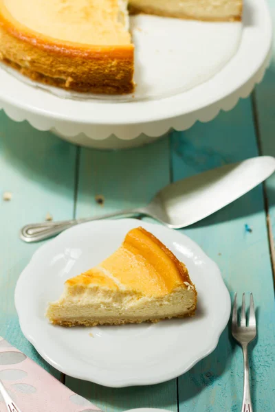 Kavrulmuş tereyağı ile peynirli kek. Mavi ahşap masa, beyaz tabaklar.