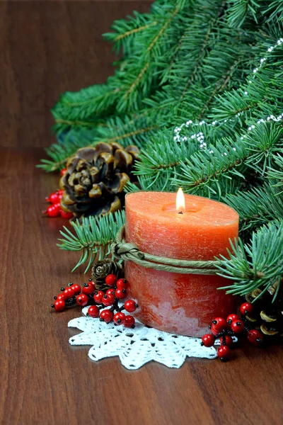 Árvore de Natal, bagas vermelhas e cones, Com uma vela acesa . — Fotografia de Stock