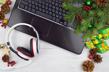 Kulaklık, bilgisayar ve Noel tinsel. Tatil melodiler.