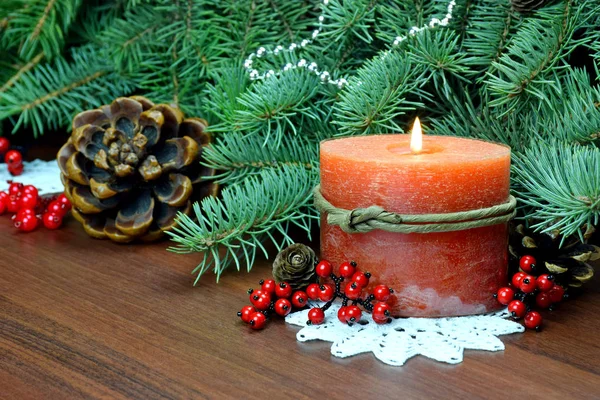 Árvore de Natal, bagas vermelhas e cones, Com uma vela acesa . — Fotografia de Stock