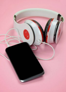 Headfones ve pembe bir arka plan üzerinde smartphone.