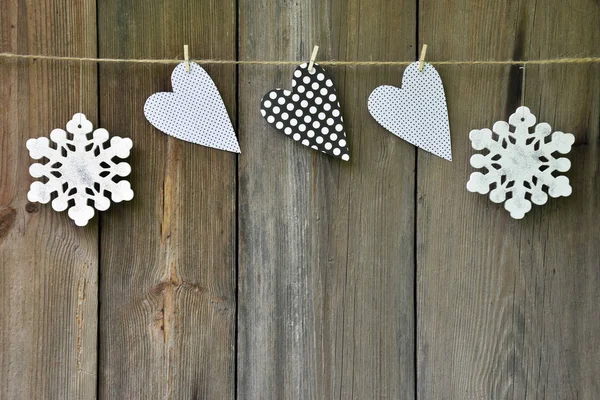 Snowflakes and hearts on old wooden background. Country style. C