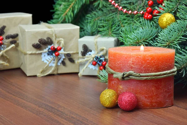 Presentes de Natal em estilo rústico e uma vela acesa . — Fotografia de Stock