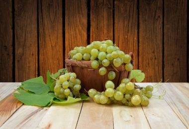 ahşap arka plan üzerinde bir sepet üzüm.