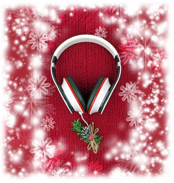 Auriculares y árbol de Navidad en una bufanda de punto rojo. Música . —  Fotos de Stock