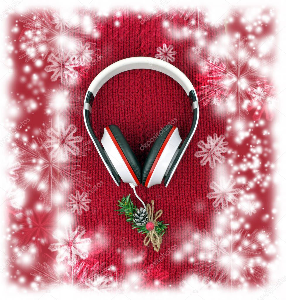 Headphones and Christmas tree on a red knitted scarf. Music.