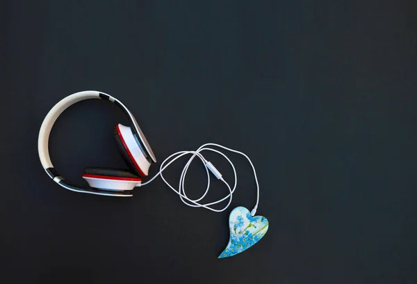 Headphones are connected by cable to the heart. Listen to your f — Stock Photo, Image