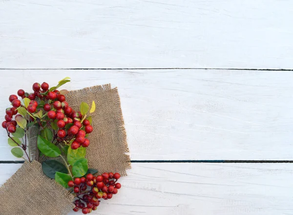 Red berries on a wooden table. The decor is rustic. — Stock Photo, Image