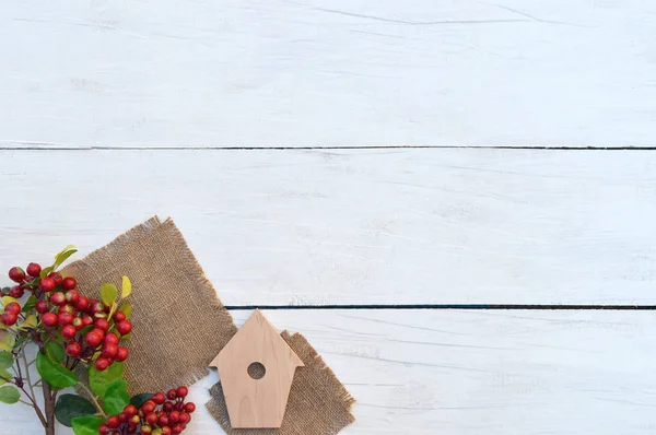Rode bessen en een vogelhuisje handgemaakte op een houten tafel. De deco — Stockfoto