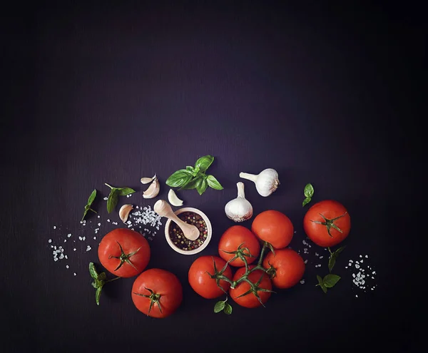 fresh basil, garlic and other herbs on a dark background. Mediterranean food healthy diet. Fresh vegetables spices and Italian herbs. tomatoes, basil and spices on a dark background