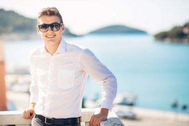 Denizin panoramik manzaralı lüks resort Hotel'de konaklamanın tadını yakışıklı delikanlı. Neşeli iş adamı kazanılan bir tropikal tatil gülümsüyor. Yaz tatili seyahat. Cruise